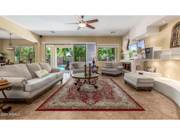 Spacious living room featuring comfortable seating, a large TV, and access to the backyard at 20371 E Calle De Flores --, Queen Creek, AZ 85142