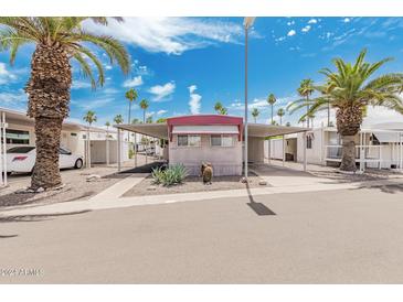 Mobile home with covered carport and desert landscaping at 305 S Val Vista Dr # 202, Mesa, AZ 85204