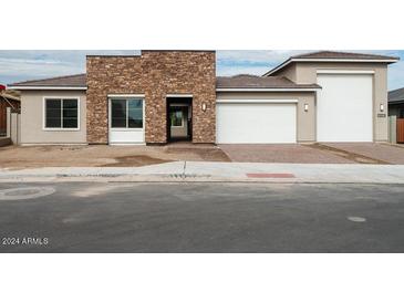 Modern home exterior with stone and stucco accents; two-car garage at 10010 S 37Th Ave, Laveen, AZ 85339