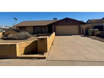 Ranch-style home with attached garage and a long driveway at 5625 N 47Th Ave, Glendale, AZ 85301