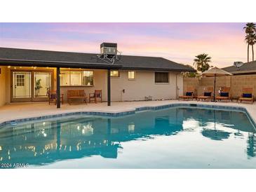 Inviting backyard oasis featuring a sparkling pool and relaxing patio furniture at 3233 S Lebanon Ln, Tempe, AZ 85282