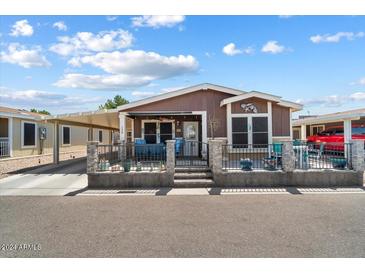 Attractive manufactured home with carport and fenced yard at 8865 E Baseline Rd # 128, Mesa, AZ 85209