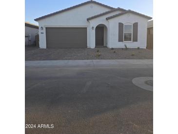 Modern home exterior with brown garage door and white walls at 40483 W Michaels Dr, Maricopa, AZ 85138