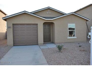 Tan house with brown garage door and small yard at 137 E Douglas Ave, Coolidge, AZ 85128