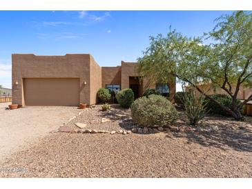 One-story stucco home with a two-car garage and desert landscaping at 48940 W Long Rifle Rd, Aguila, AZ 85320