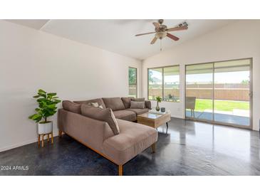 Relaxing living room with L-shaped sectional sofa and sliding doors to backyard at 35066 N Happy Jack Dr, San Tan Valley, AZ 85144