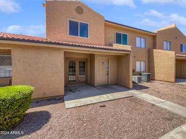 Tan two-story stucco condo with double doors and small front yard at 3511 E Baseline Rd # 1031, Phoenix, AZ 85042