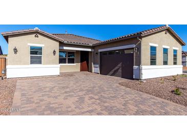 One-story home with a brown garage door, a paved driveway, and desert landscaping at 16348 W Avenida Del Sol --, Surprise, AZ 85387