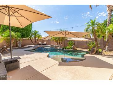 Inviting freeform pool with large patio and umbrellas at 675 W Longhorn Dr, Chandler, AZ 85286