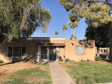 Brick home with a well maintained yard at 605 N Lesueur Cir, Mesa, AZ 85203
