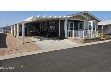 Mobile home with covered carport and landscaped yard at 650 N Hawes Rd # 3809, Mesa, AZ 85207