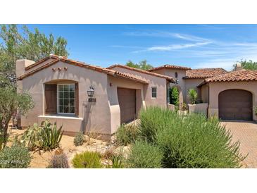 Exterior view of a beautiful home with a Spanish-style design and landscaping at 8874 E Flathorn Dr, Scottsdale, AZ 85255