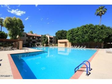 Community pool with surrounding lounge chairs at 3031 N Civic Center Plz # 230, Scottsdale, AZ 85251