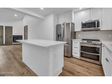 Modern kitchen with white cabinets, stainless steel appliances and island at 19820 N 13Th Ave # 205, Phoenix, AZ 85027