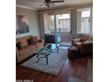 Bright living room with hardwood floors, comfy seating and glass coffee table at 7009 E Acoma Dr # 2037, Scottsdale, AZ 85254