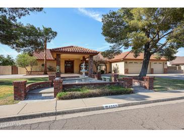 Beautiful home exterior with a fountain and mature landscaping at 4112 W Paradise Ln, Phoenix, AZ 85053