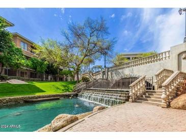 Scenic waterway with a cascading waterfall and lush landscaping at 2989 N 44Th St # 3036, Phoenix, AZ 85018