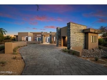 Stunning modern home with stone accents and a paved driveway at 10249 E Joy Ranch Rd, Scottsdale, AZ 85262