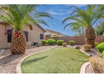 Landscaped backyard with artificial turf and desert landscaping at 44152 W Garden Ln, Maricopa, AZ 85139