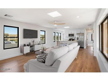 Open living space with hardwood floors, modern kitchen, and large windows at 16844 E Ave Of The Fountains -- # 202, Fountain Hills, AZ 85268