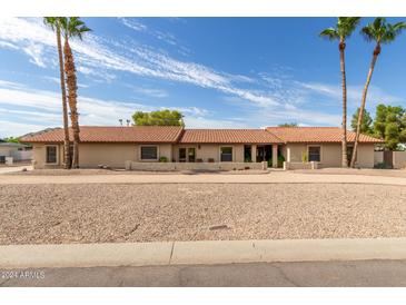 Single-story home with desert landscaping and a long driveway at 5202 W Soft Wind Dr, Glendale, AZ 85310