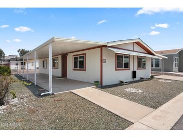 Single-wide manufactured home with covered carport and landscaped yard at 3330 E Main St # 440, Mesa, AZ 85213