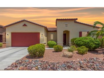 Single-story home with red garage door and landscaped front yard at 20285 N Winter Escape Ct, Maricopa, AZ 85138