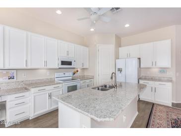 Modern kitchen with white cabinets, granite countertops, and stainless steel appliances at 20285 N Winter Escape Ct, Maricopa, AZ 85138