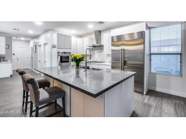 Modern kitchen with stainless steel appliances and a large kitchen island at 6603 W Via Dona Rd, Phoenix, AZ 85083