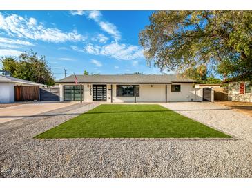 Mid-century modern home with artificial turf and updated landscaping at 1236 E Mclellan Blvd, Phoenix, AZ 85014