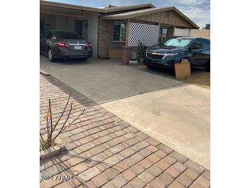 Brick ranch home with a covered carport and large driveway at 303 N 7Th St, Avondale, AZ 85323