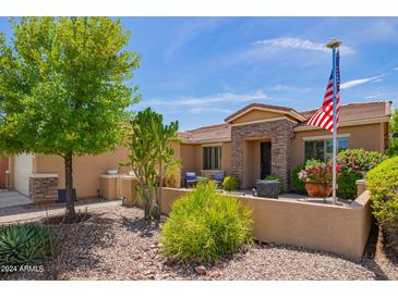 Single-story home with landscaped front yard and American flag at 20980 N Sweet Dreams Dr, Maricopa, AZ 85138