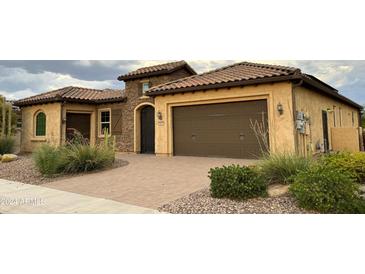 Spanish style home with two-car garage and landscaping at 3981 N Hudson Dr, Florence, AZ 85132