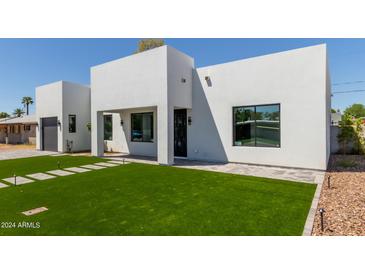 Modern home with artificial turf, gray driveway, and walkway at 3014 E Avalon Dr, Phoenix, AZ 85016