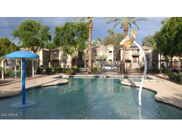 Community pool with water features and a shaded seating area at 7844 W Bonitos Dr, Phoenix, AZ 85035