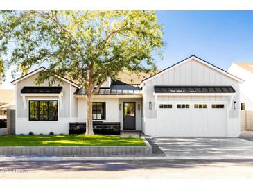 Modern farmhouse style home with white and gray siding, landscaping and a two-car garage at 6836 N 13Th Pl # A, Phoenix, AZ 85014