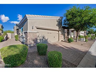 Tan house with two car garage, landscaping and brick driveway at 6202 E Mckellips Rd # 310, Mesa, AZ 85215