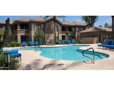 Freeform community pool with blue lounge chairs at 7027 N Scottsdale Rd # 237, Scottsdale, AZ 85253