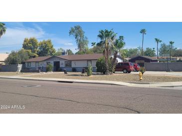 Single story home with a landscaped yard and driveway at 3401 E Paradise Ln, Phoenix, AZ 85032