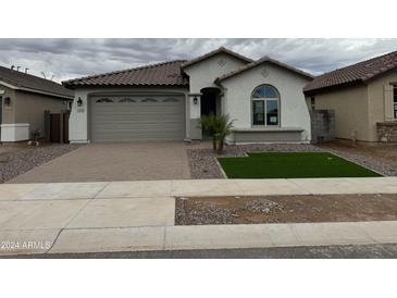 Two-car garage with neutral-toned exterior and artificial turf at 24066 N 162Nd Ln, Surprise, AZ 85387