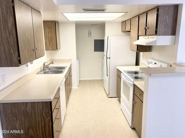 Galley style kitchen with wood cabinets and white appliances at 4608 W Maryland Ave # 144, Glendale, AZ 85301