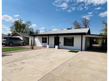 Updated single story home with artificial turf and a paved driveway at 630 W 1St St, Mesa, AZ 85201