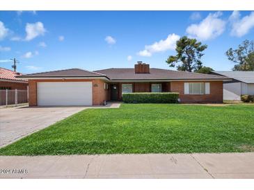Brick ranch home with a well-maintained lawn at 845 W Edgemont Ave, Phoenix, AZ 85007