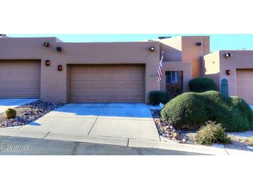 Tan stucco exterior with two-car garage and nicely landscaped front yard at 17025 E La Montana Dr # 107, Fountain Hills, AZ 85268