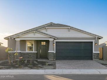 Single-story home with dark gray garage door and stone accents at 4651 N 177Th Ln, Goodyear, AZ 85395