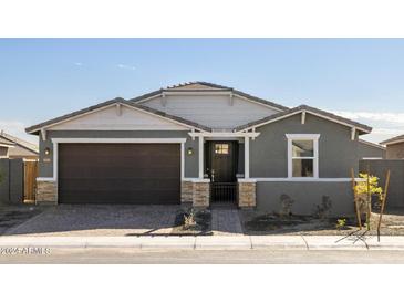 Single-story home with gray exterior, brown garage door, and stone accents at 4657 N 177Th Ln, Goodyear, AZ 85395