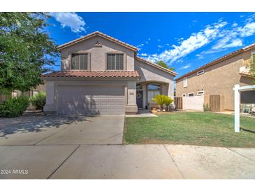 Two-story house with a gray garage door and well-maintained lawn at 7216 W Irma Ln, Glendale, AZ 85308