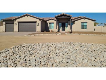 Single-story home with a two-car garage and desert landscaping at 48515 N 13Th Ave, New River, AZ 85087