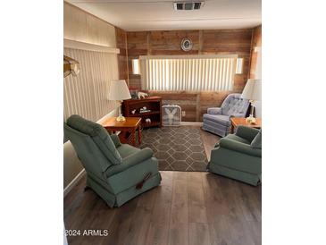 Cozy living room with wood-paneled walls and comfy armchairs at 2701 E Allred Ave # 68, Mesa, AZ 85204