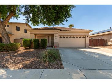 Single-story house with tan exterior and two-car garage at 14623 W Hearn Rd, Surprise, AZ 85379